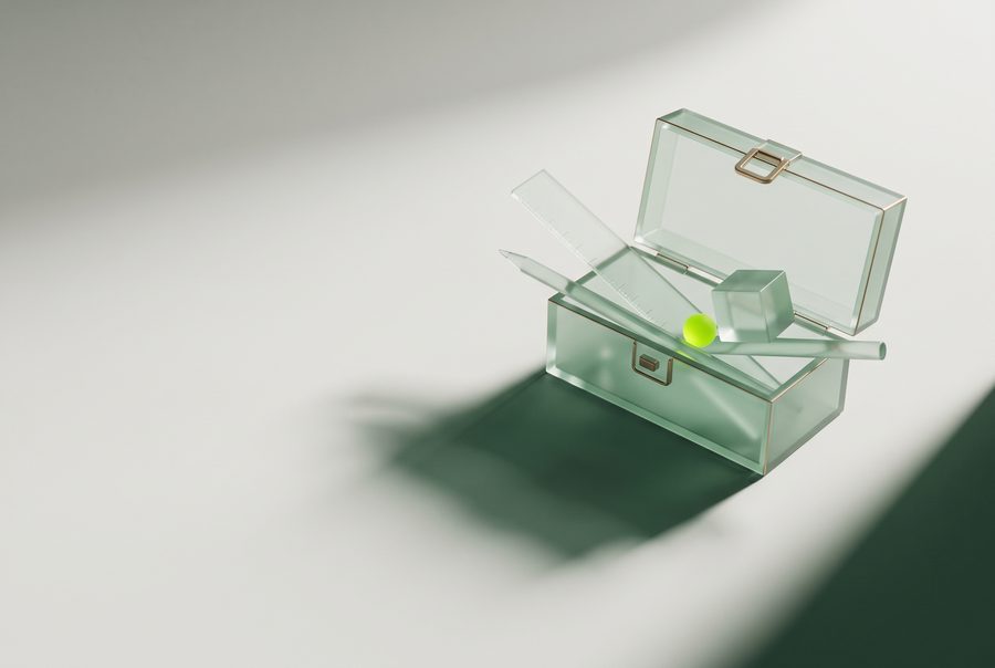 Illustration: an open glass toolbox holding a ruler, a pen, a cube and one small lime sphere.